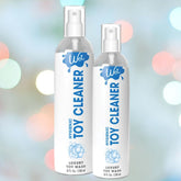 Two bottles of Wet Hygenic Sex Toy Cleaner against a soft, out-of-focus, multicolored background. The bottles are white with blue branding and text from Wet, one larger at 8 fl oz (236 ml) and the other smaller. Enjoy hygienic fun with this luxury cleaner designed to keep your toys pristine.